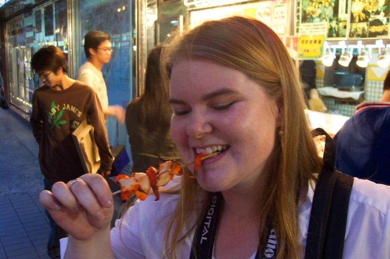 Tegan eating squid on a stick